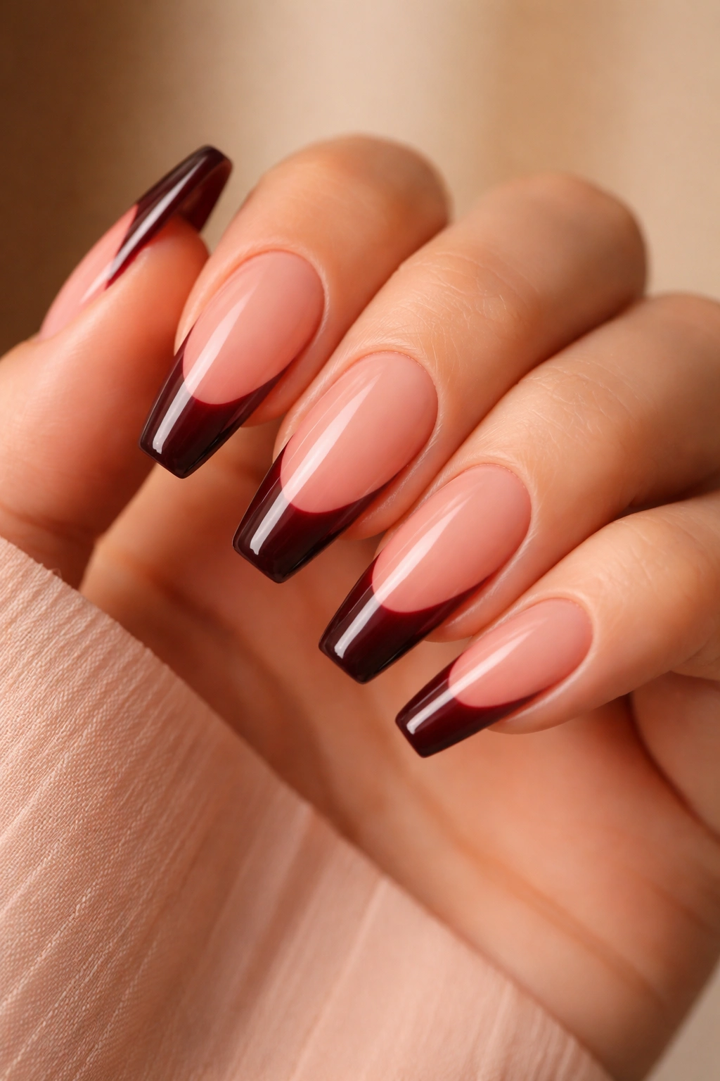 Nails showcasing burgundy tips with pink undertone and peachy-pink base