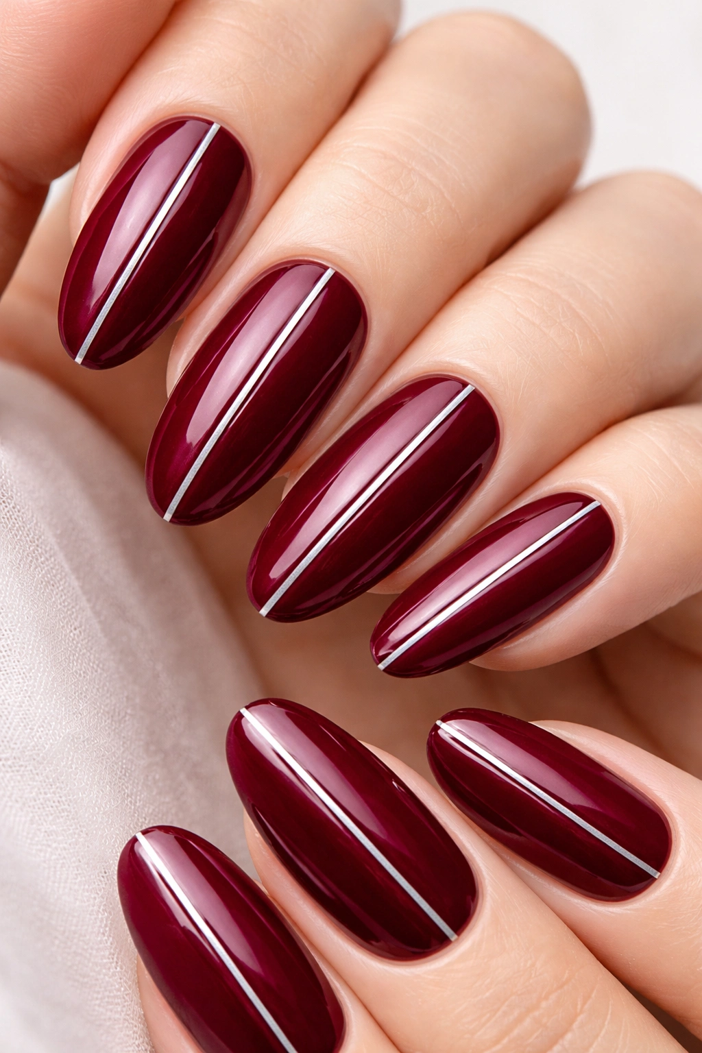 Burgundy nails with thin silver stripes