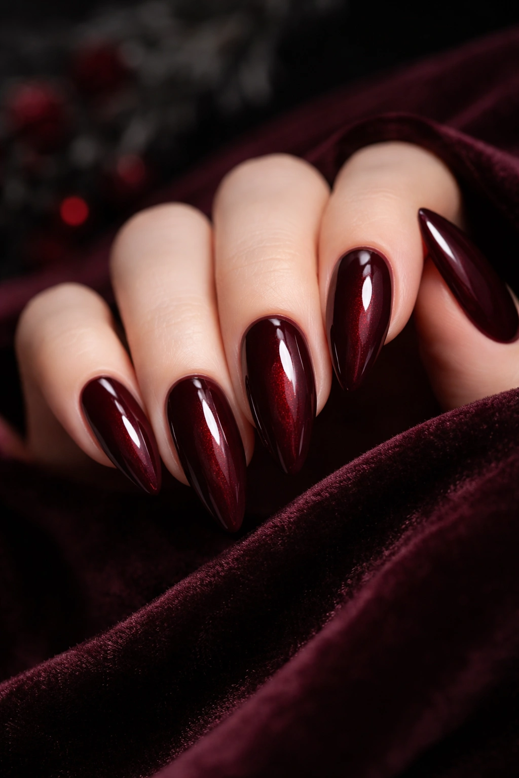Close-up of hand showing moody dark burgundy wine nails.