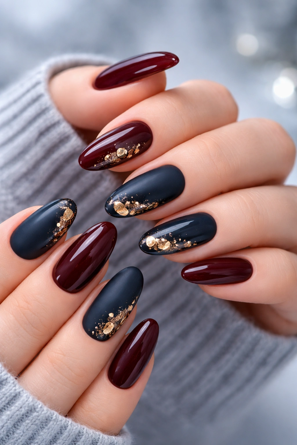 Nails in burgundy and navy with gold foil accents