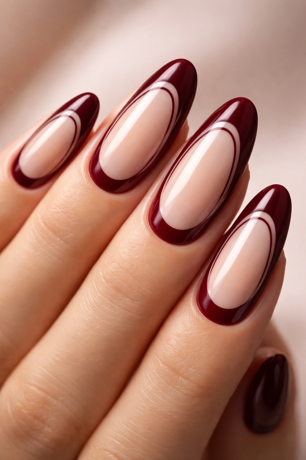 Nails with burgundy borders and nude center negative-space design