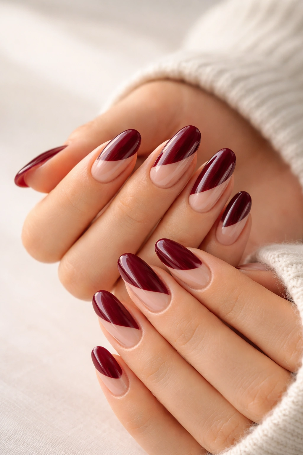 Long oval burgundy nails with negative-space design and bare crescents