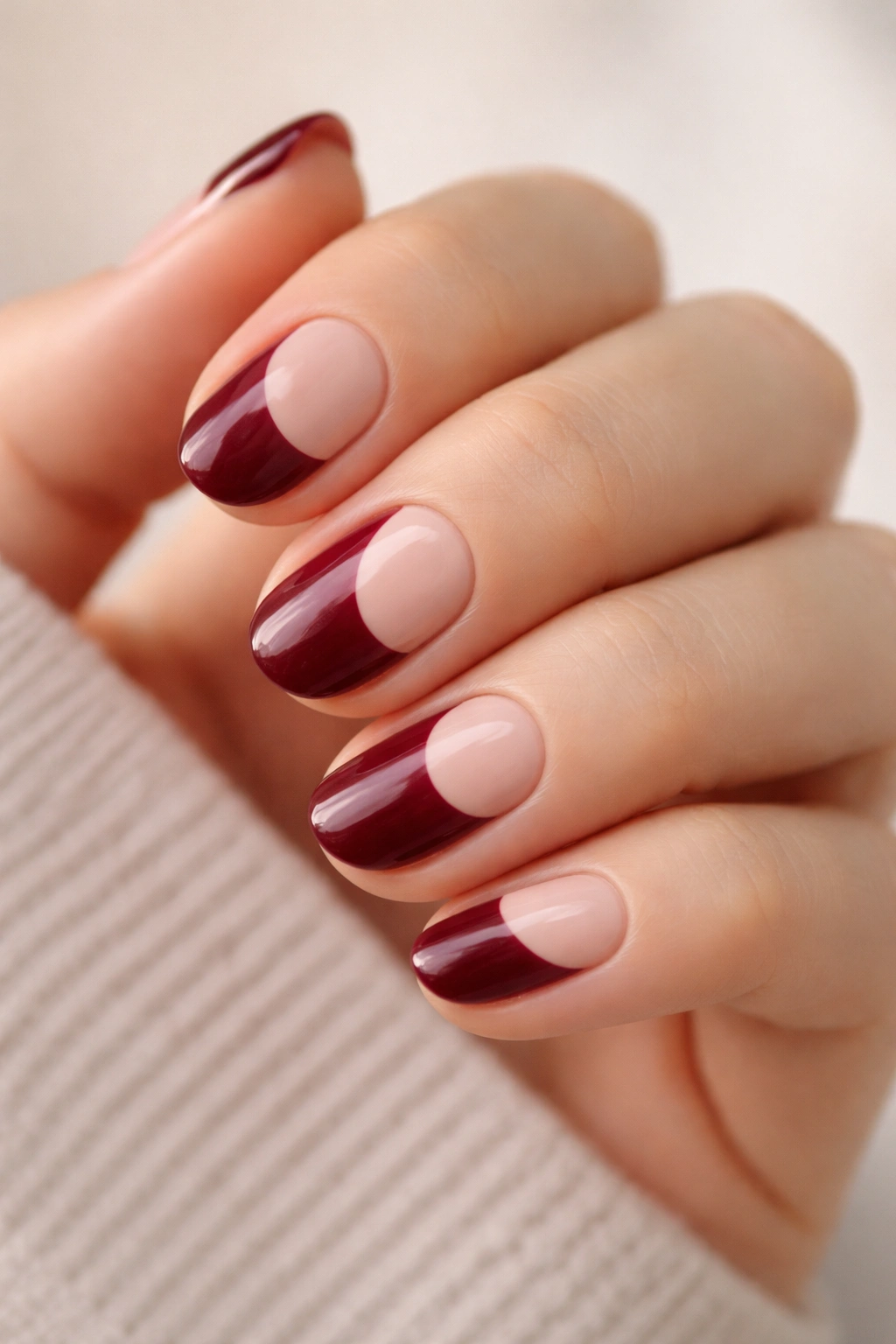 Nude-based short oval nails with burgundy color-block panels