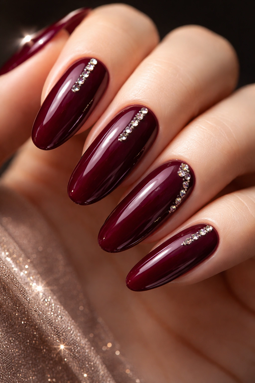 Close-up of deep burgundy nails with a delicate rhinestone line
