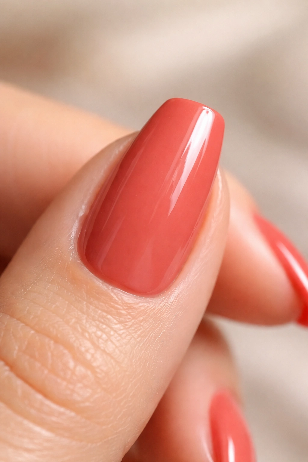 Short ballerina nail in burnt coral red with cream finish