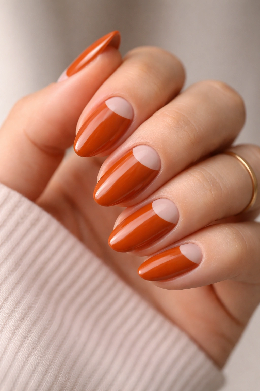 Close-up of burnt orange almond nails with nude cuticle gaps