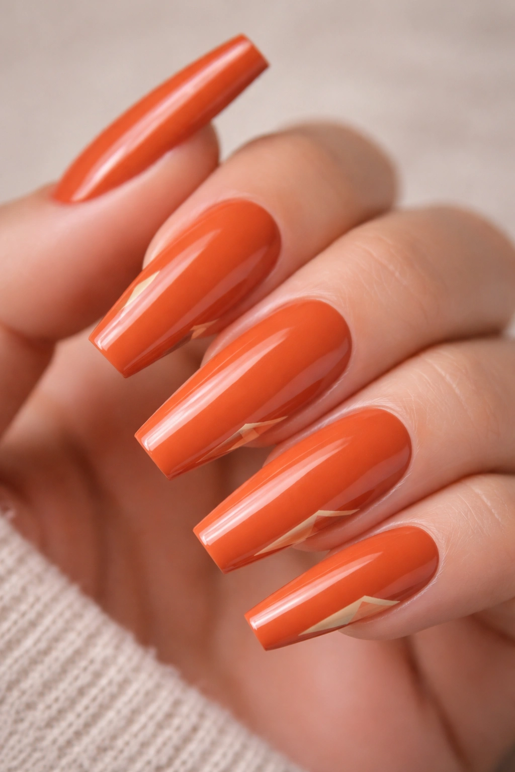 Long coffin nails in burnt orange with minimalist corner design.