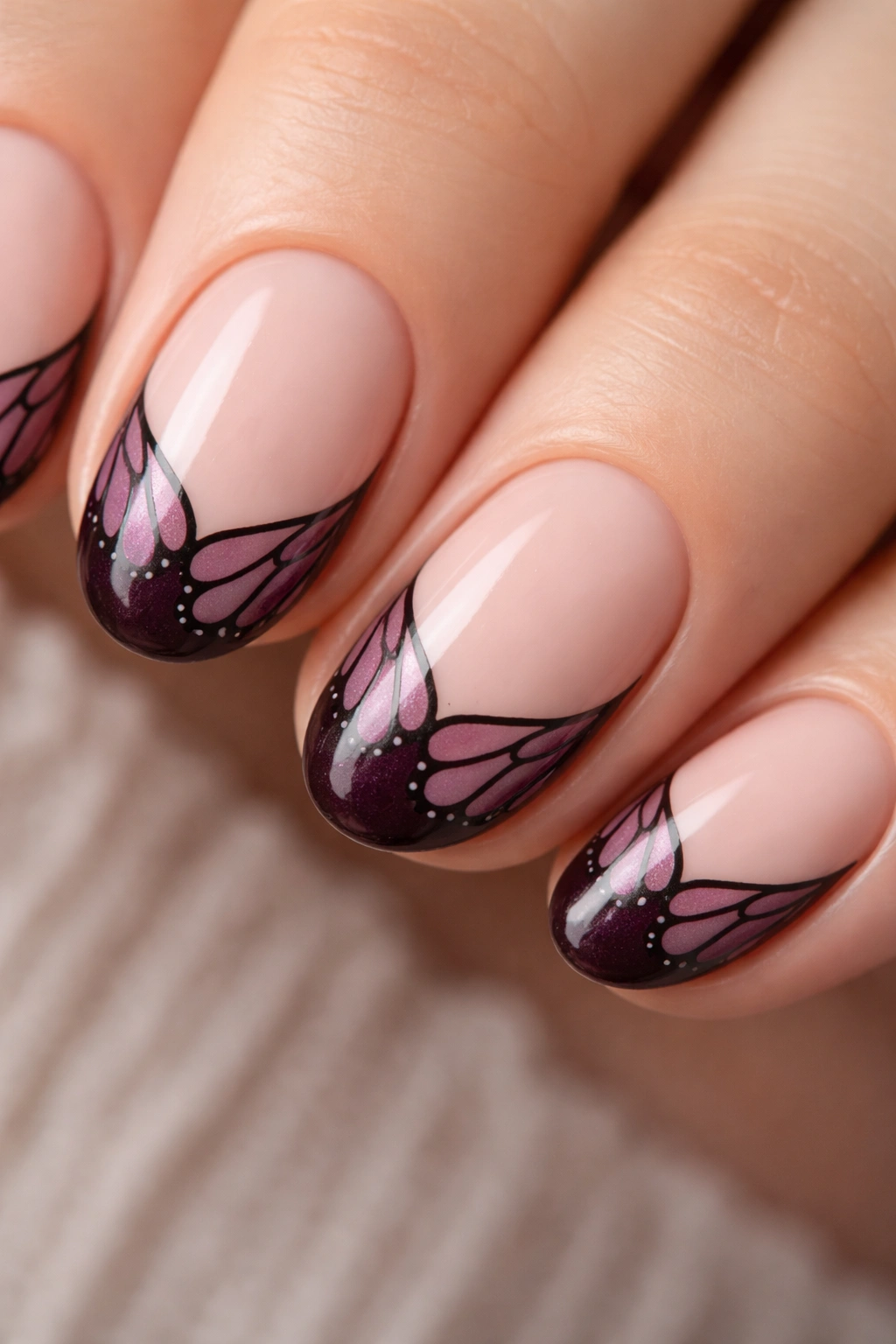 Close-up of a short oval nail with butterfly wing tips curving along the nail arc