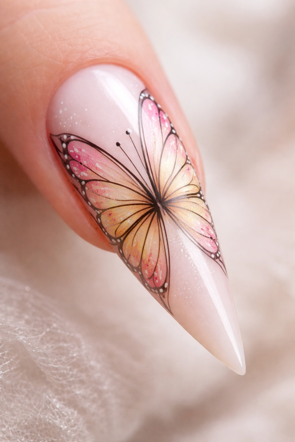 Macro close-up of a stiletto nail with butterfly wing gradient design in pastel colors