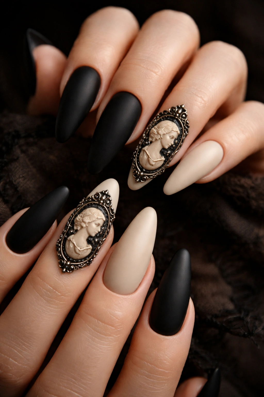 Close-up of Victorian cameo nails in black and bone tones with single cameo accent on ring fingers