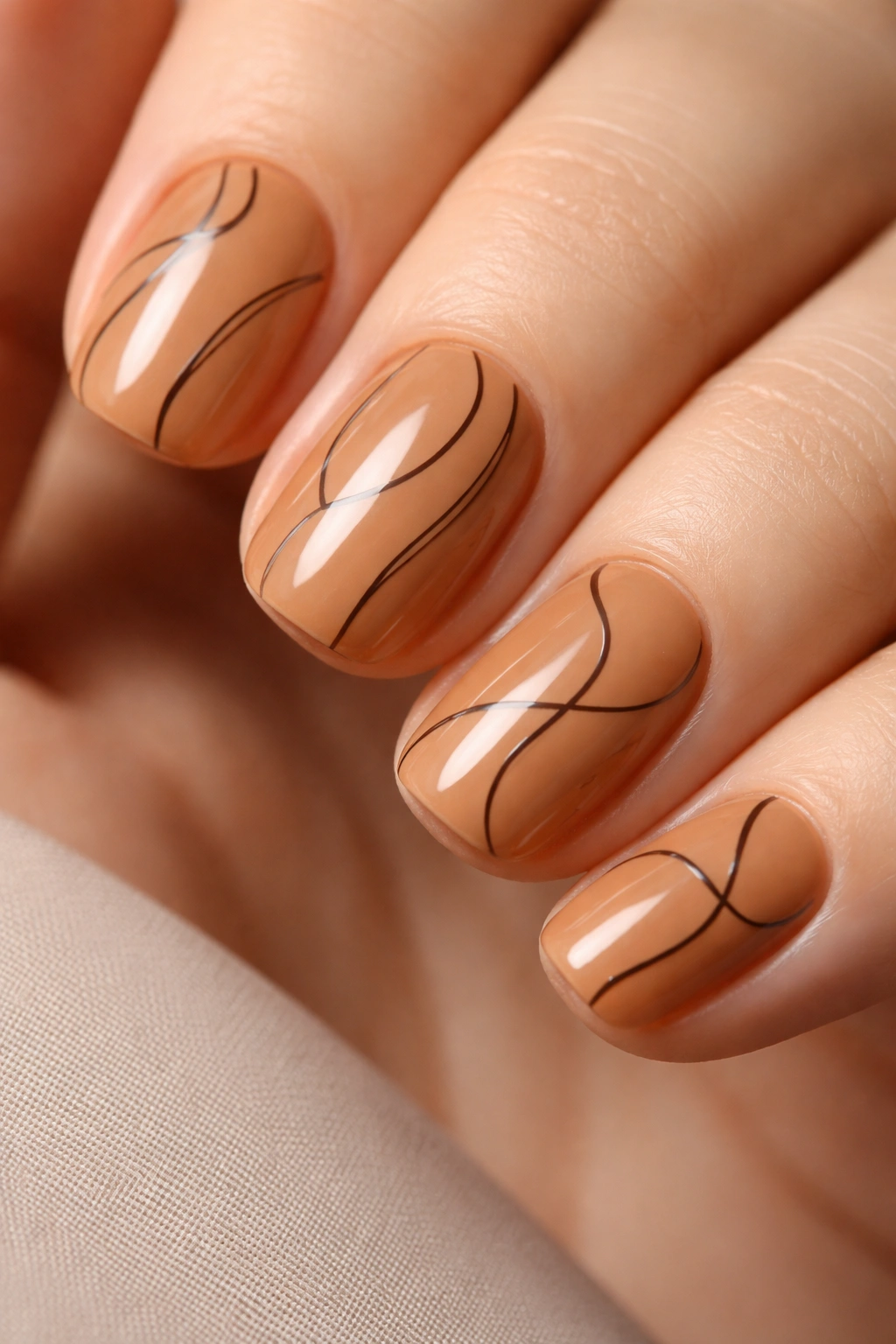Caramel nails with minimalist abstract lines close-up