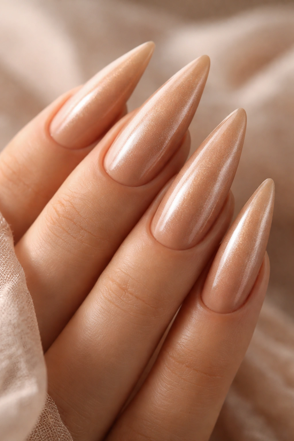 Close-up of caramel nude stiletto nails with pearl glow