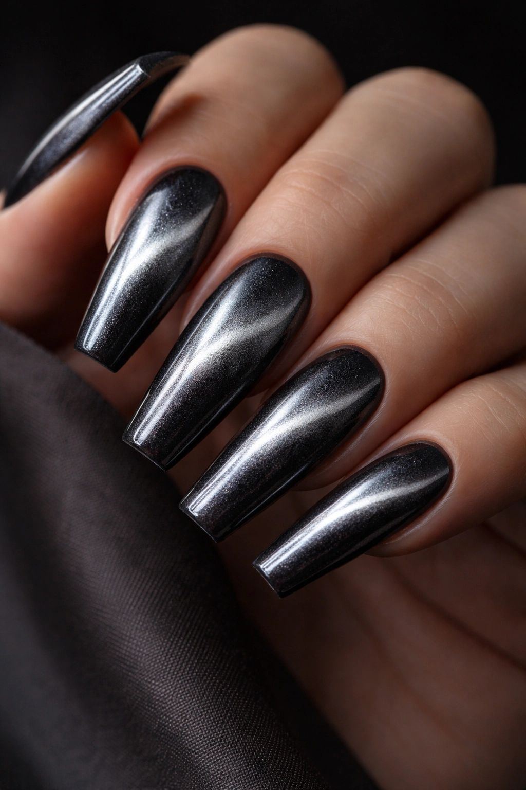 Close up of long ballerina nails with a gunmetal cat-eye effect