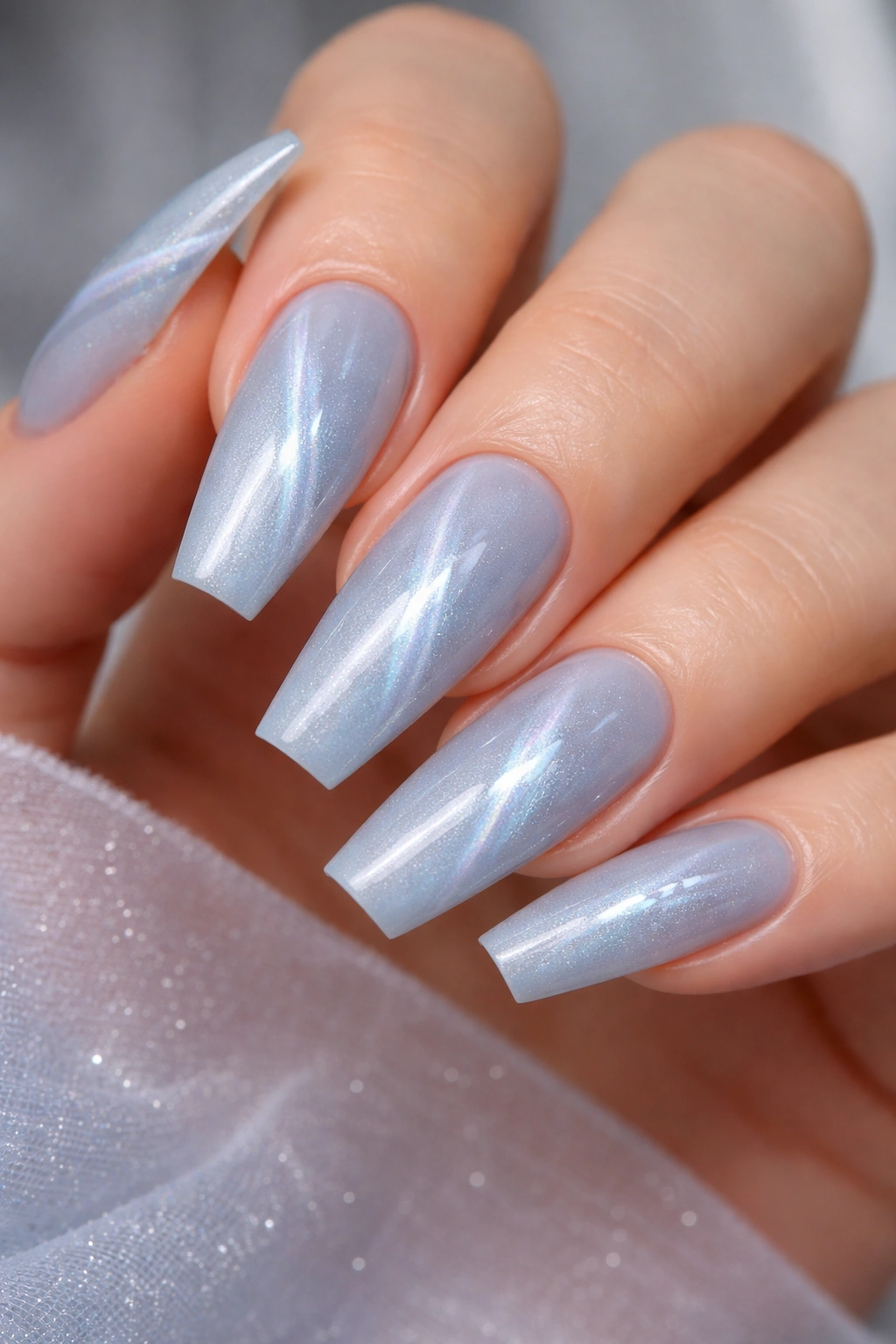 Icy blue cat-eye nails on ballerina shape with off-center magnet line
