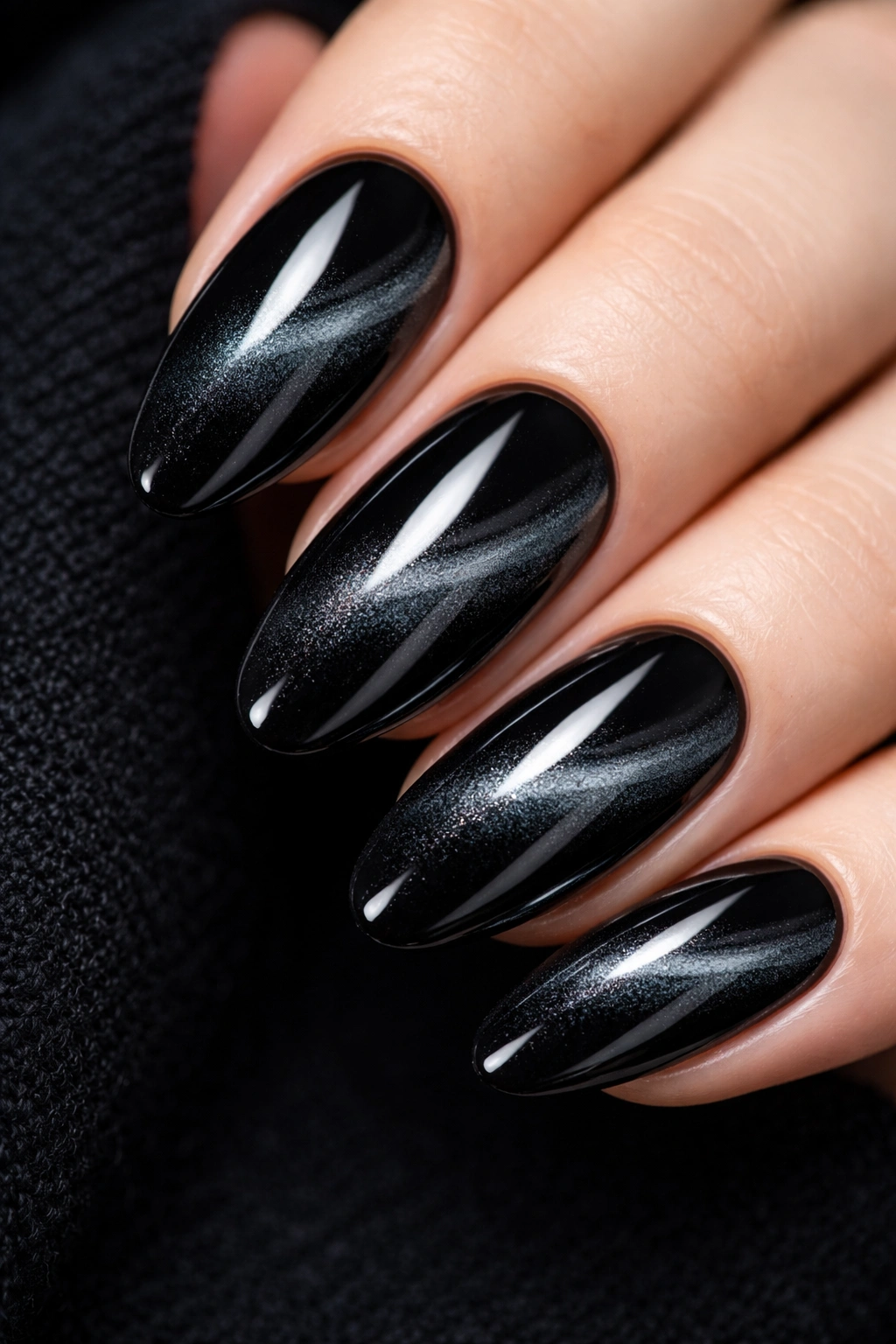 Close-up of black cat-eye nails with a magnetic linear pattern