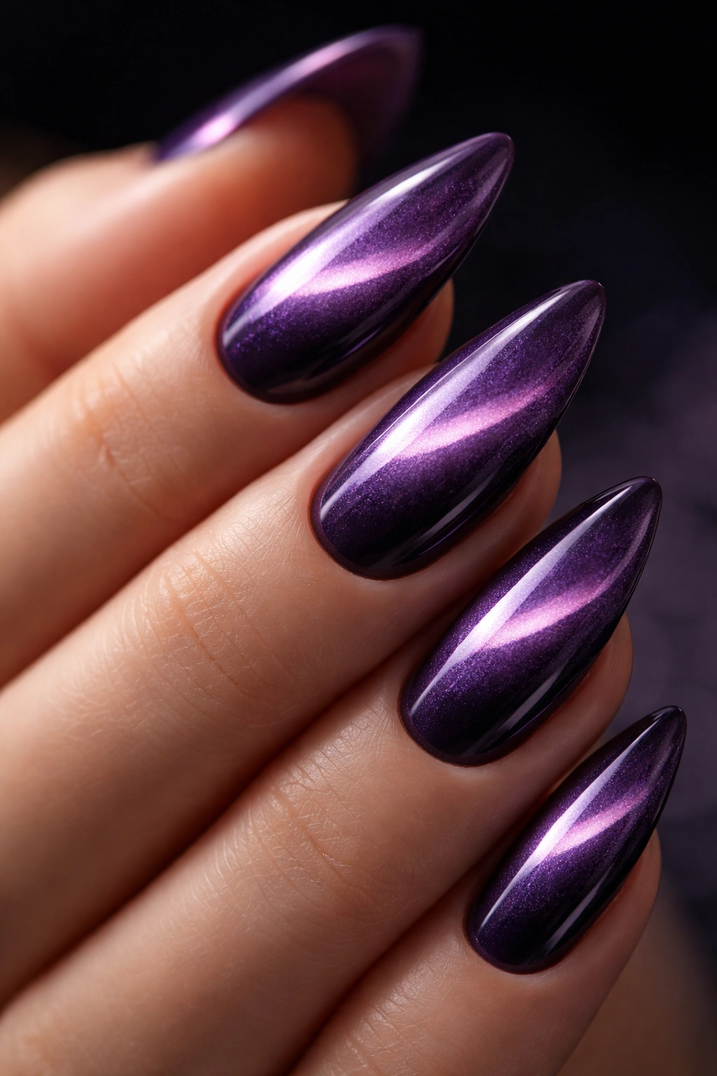 Close-up of purple cat-eye almond nails showing the magnetic stripe