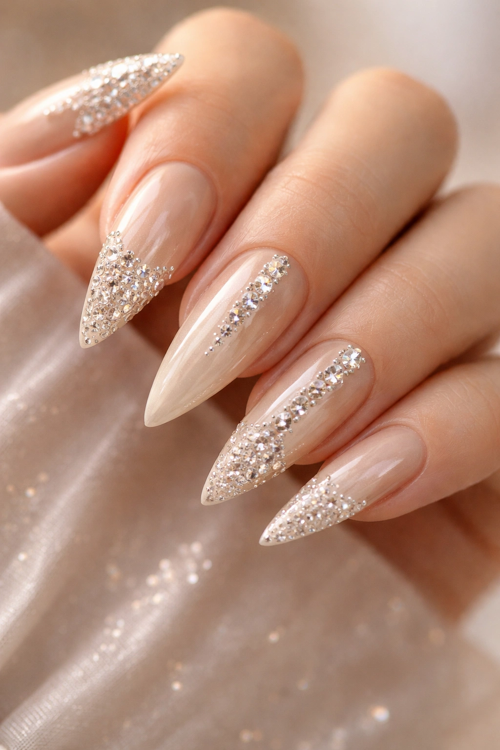 Champagne-toned stiletto nails with rhinestones arranged in gradient