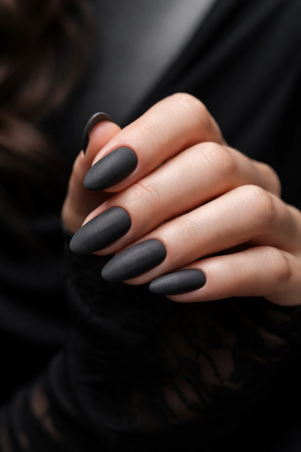 Moody charcoal gray matte nails on a hand for sleek monochrome fashion manicure
