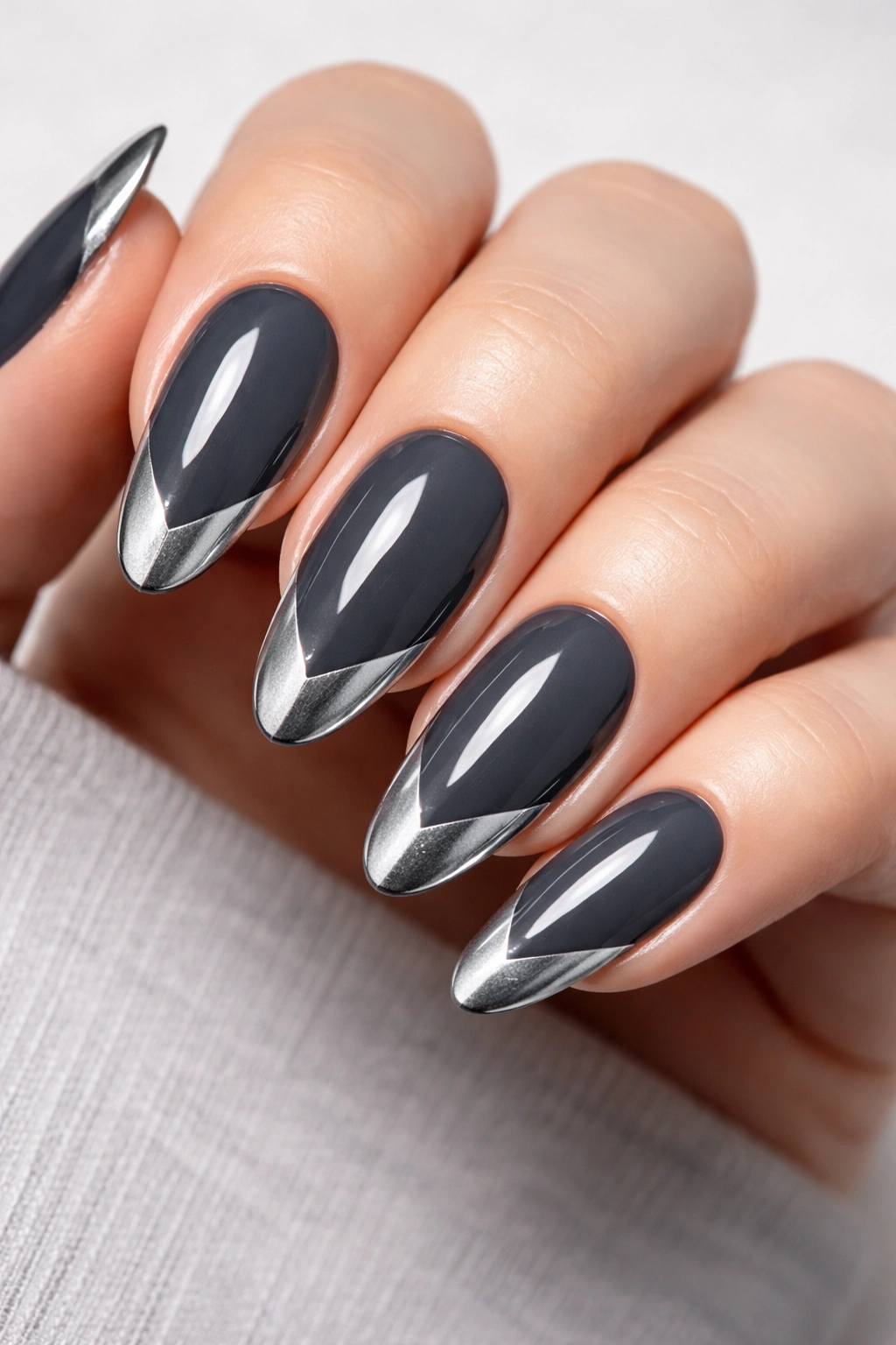 Close-up of charcoal gray nails with silver chevron tips on long round nails