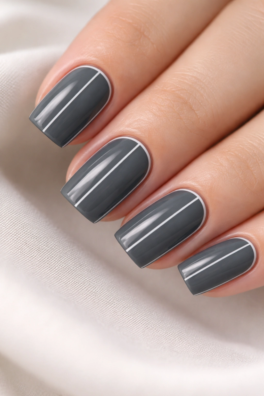 Charcoal gray nails with ultra-fine white line accents on short soft square nails