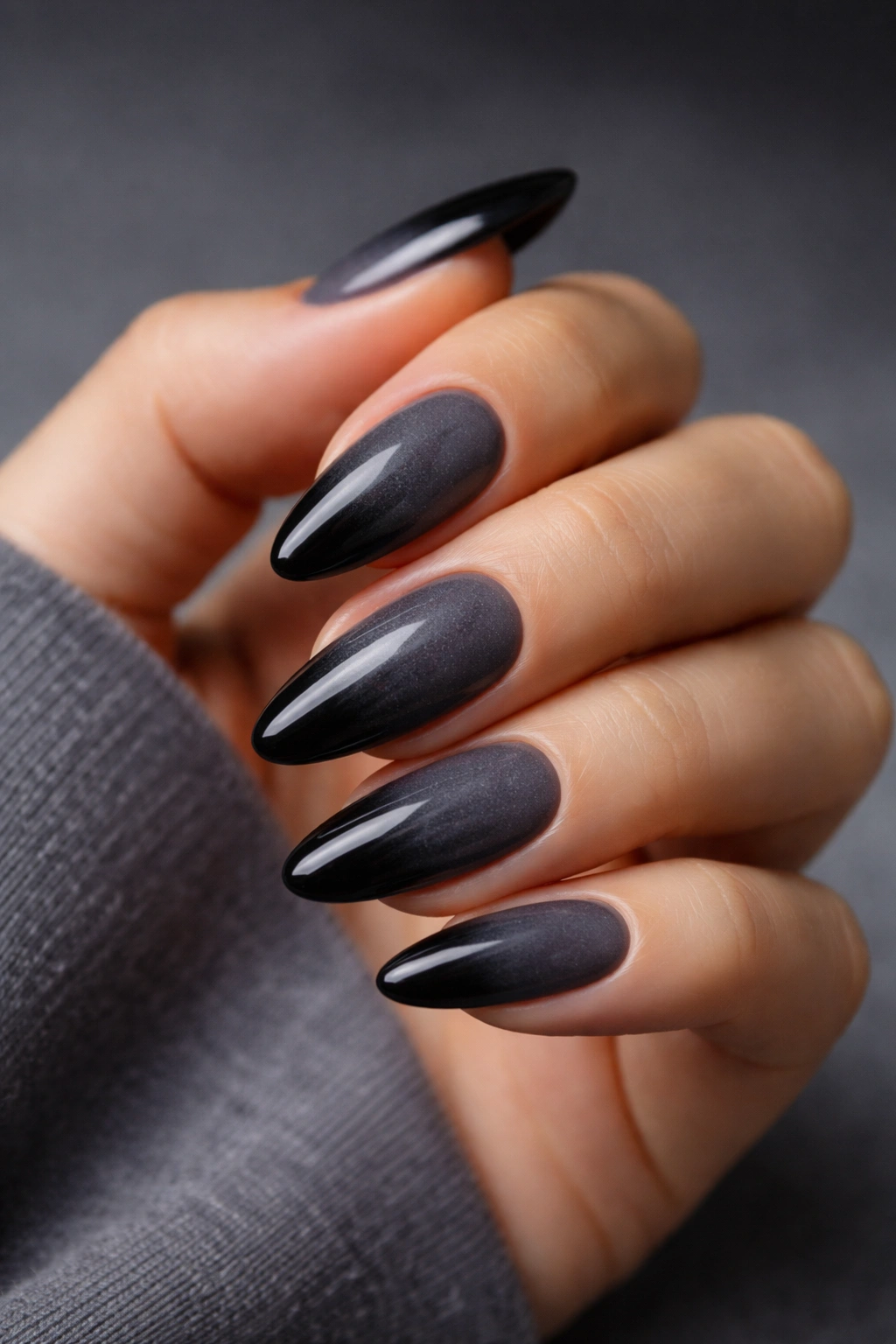 Close-up of almond nails with charcoal to black gradient