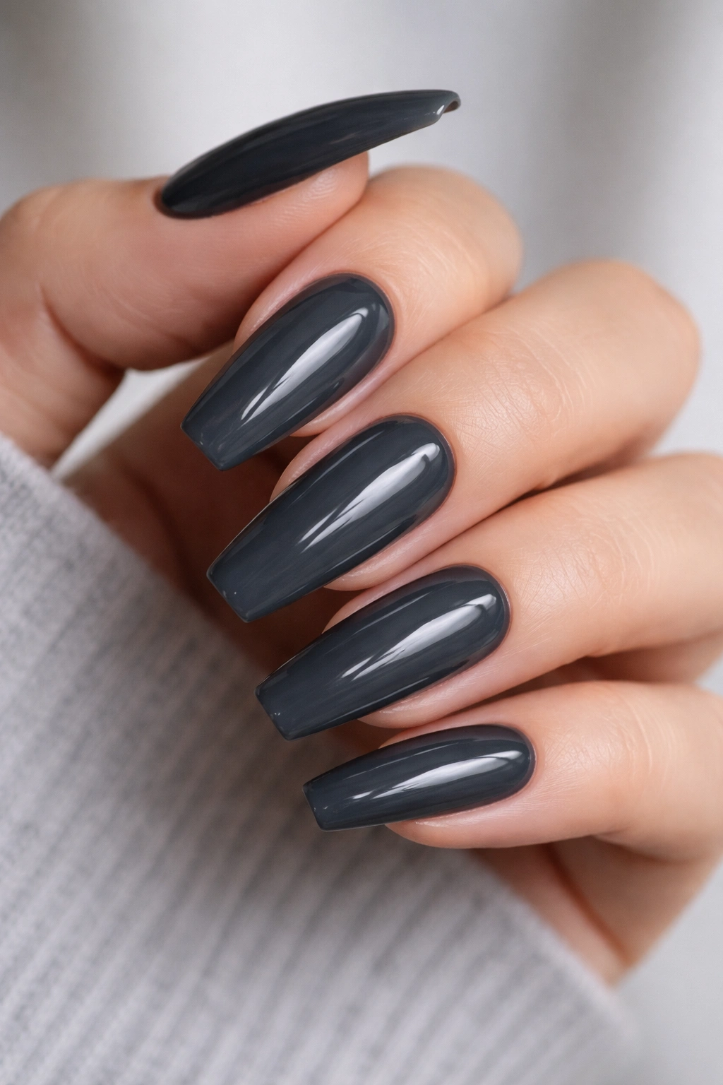 Close-up of glossy charcoal ballerina nails on clean hands
