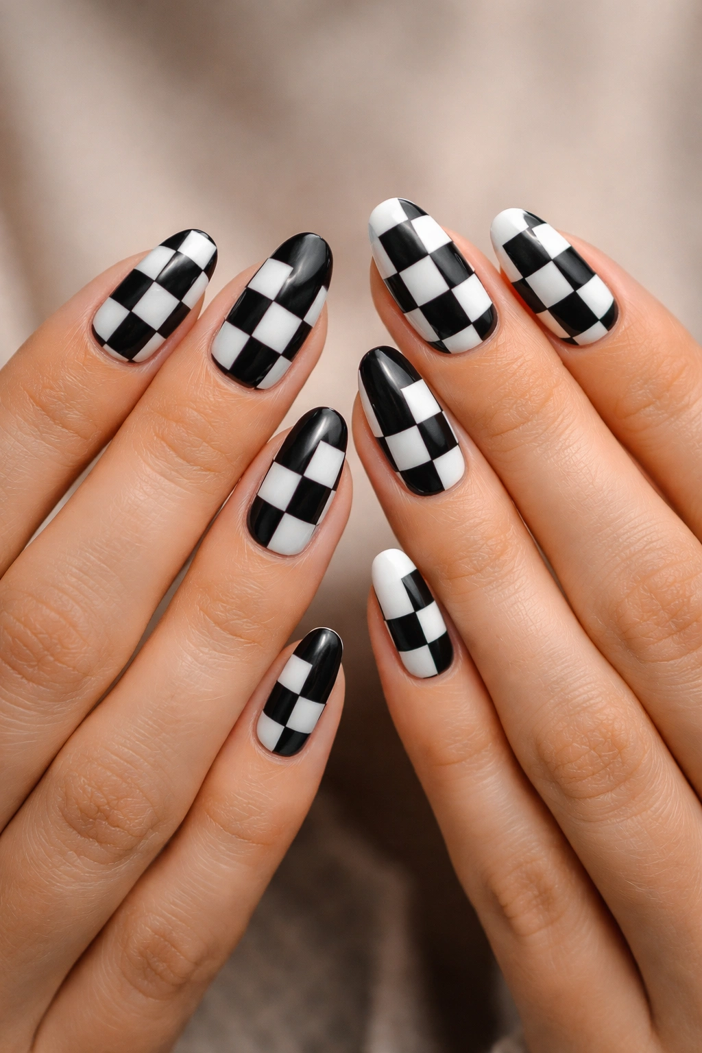 Two hands with swapped black-and-white checkered nails