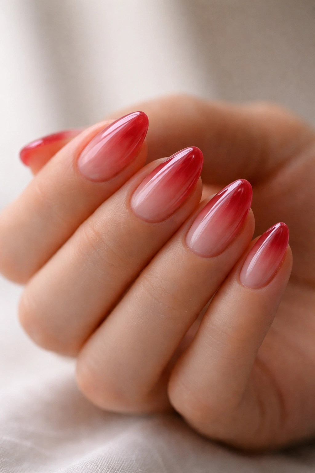 Close-up of short nails in translucent cherry jelly with a delicate tapered tip