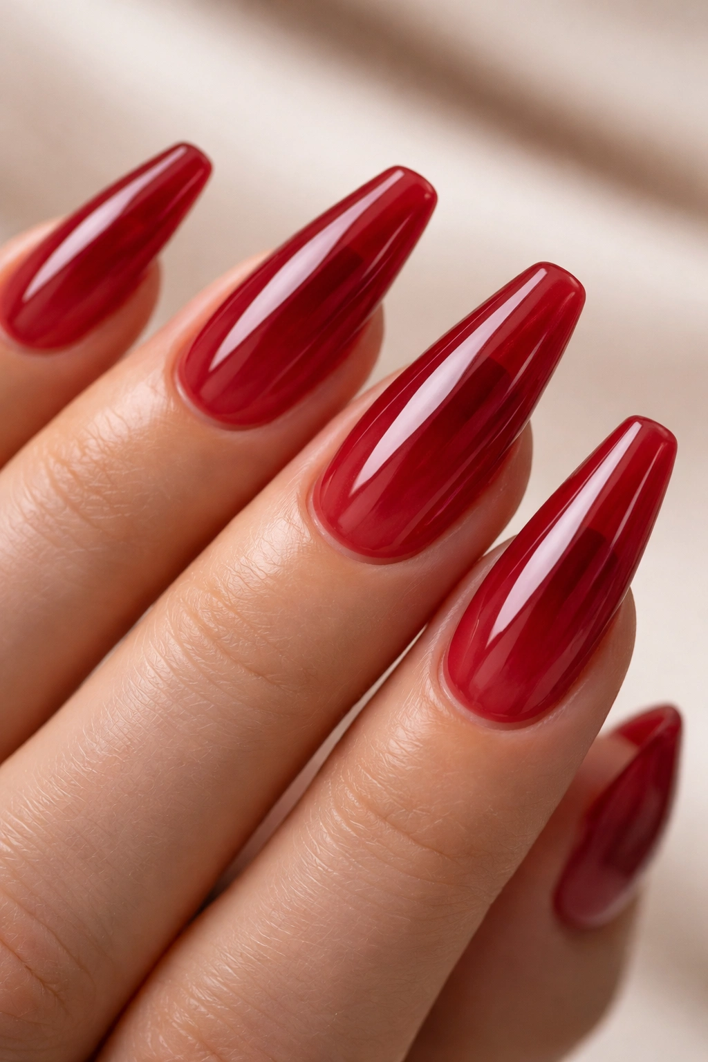 Hand with cherry jelly red nails showing translucent jelly finish