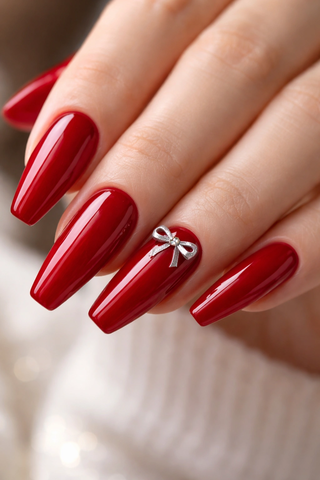 Cherry red nails with a single bow accent