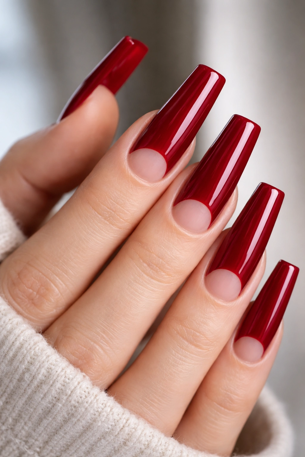 Long coffin nails in cherry red with bare half-moon cutouts