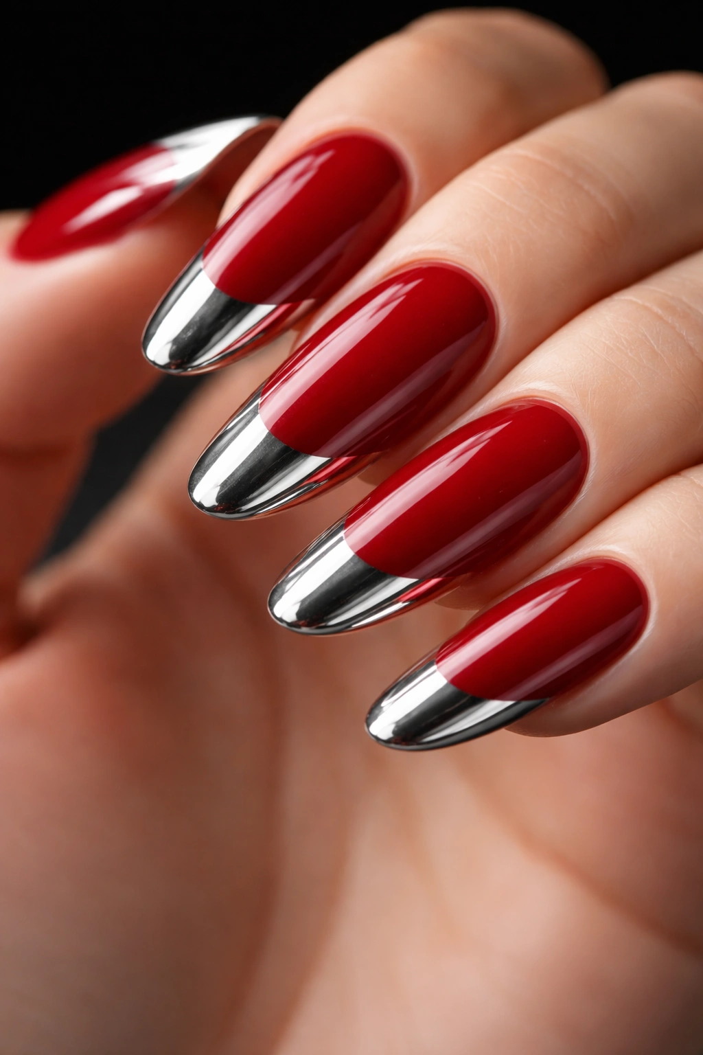 Nails with cherry red base and metallic chrome/mirror tips.
