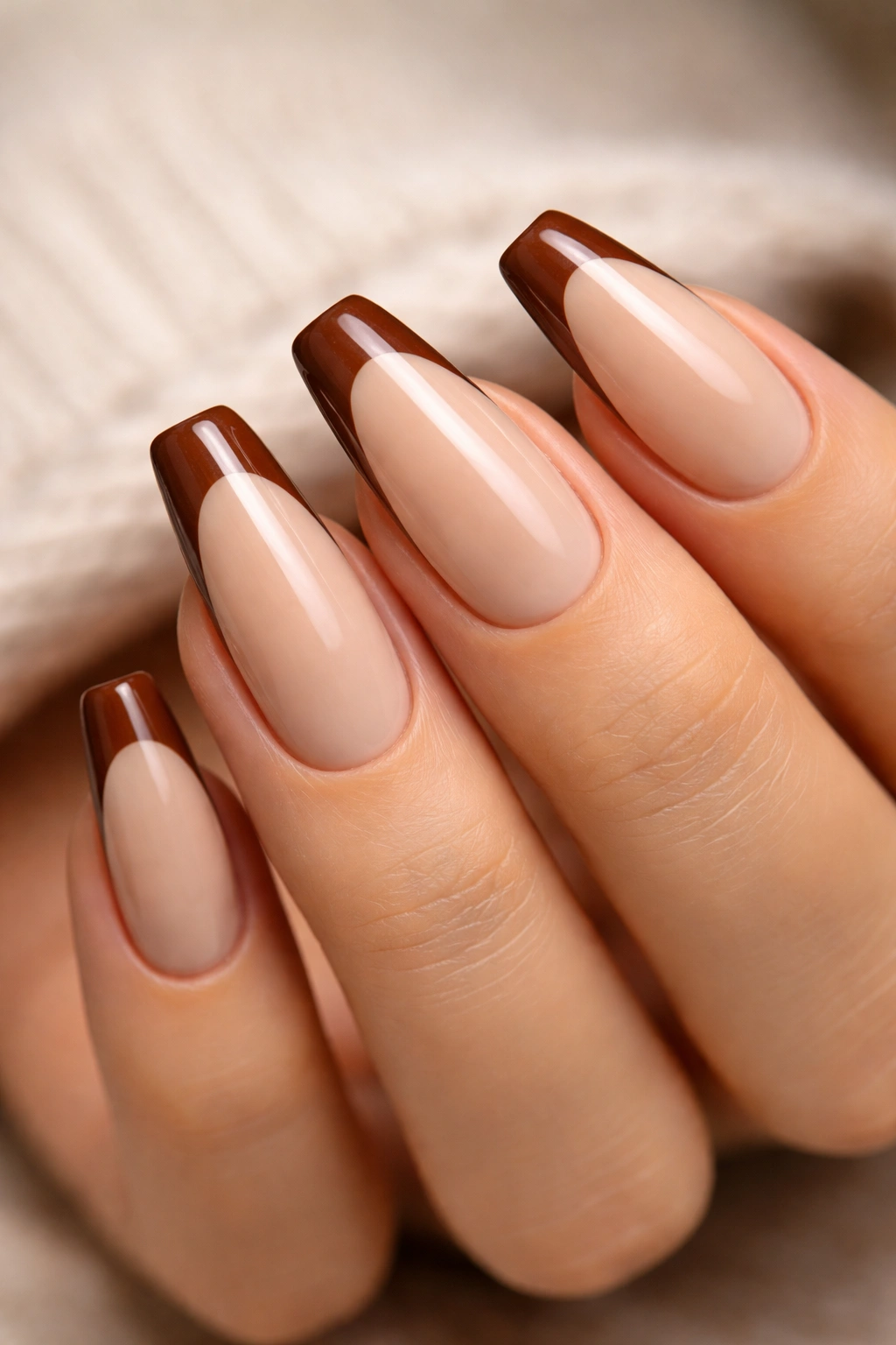Chestnut French tips on milky nude base nails in ballerina shape