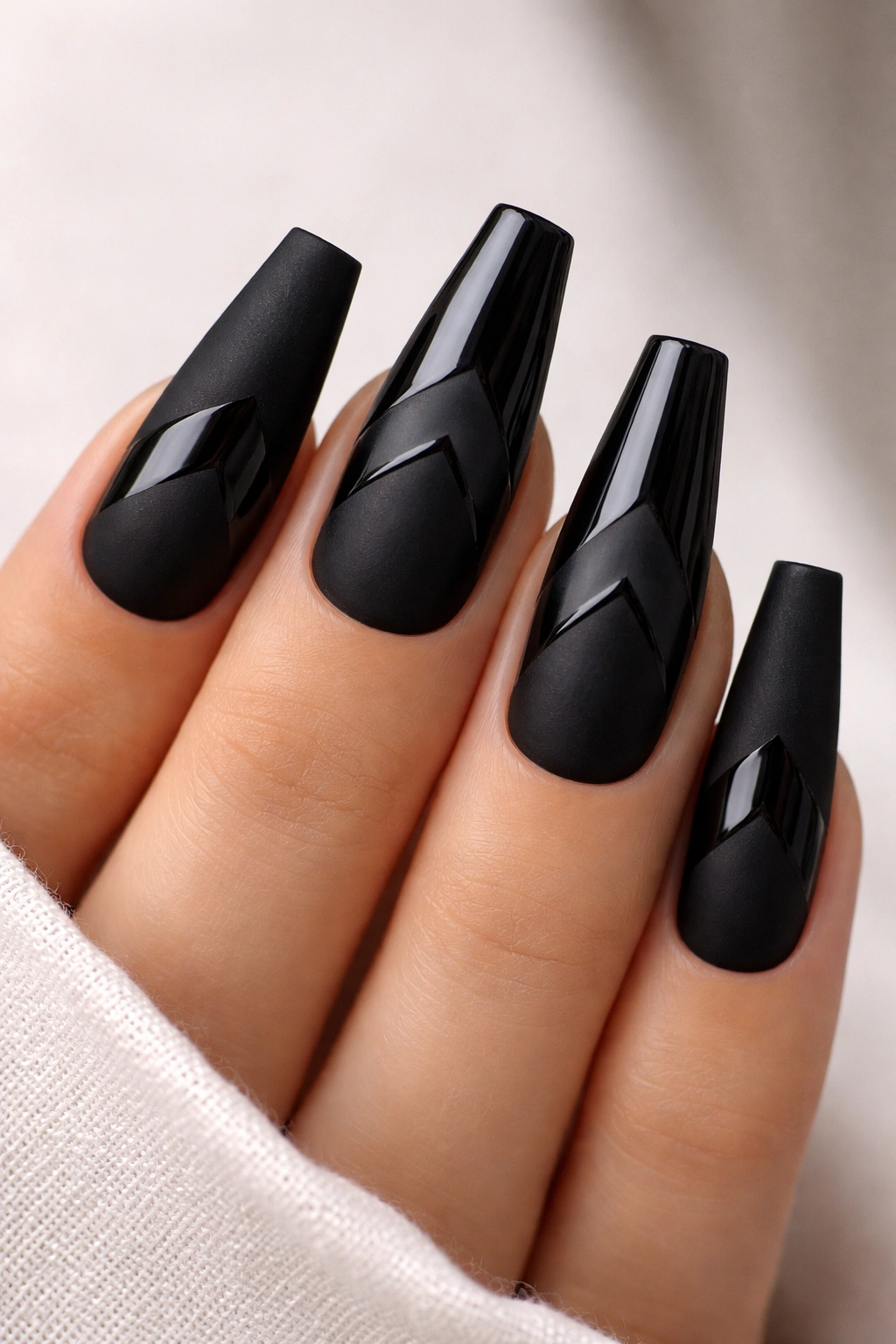 Matte and gloss black chevron nails with tonal contrast.