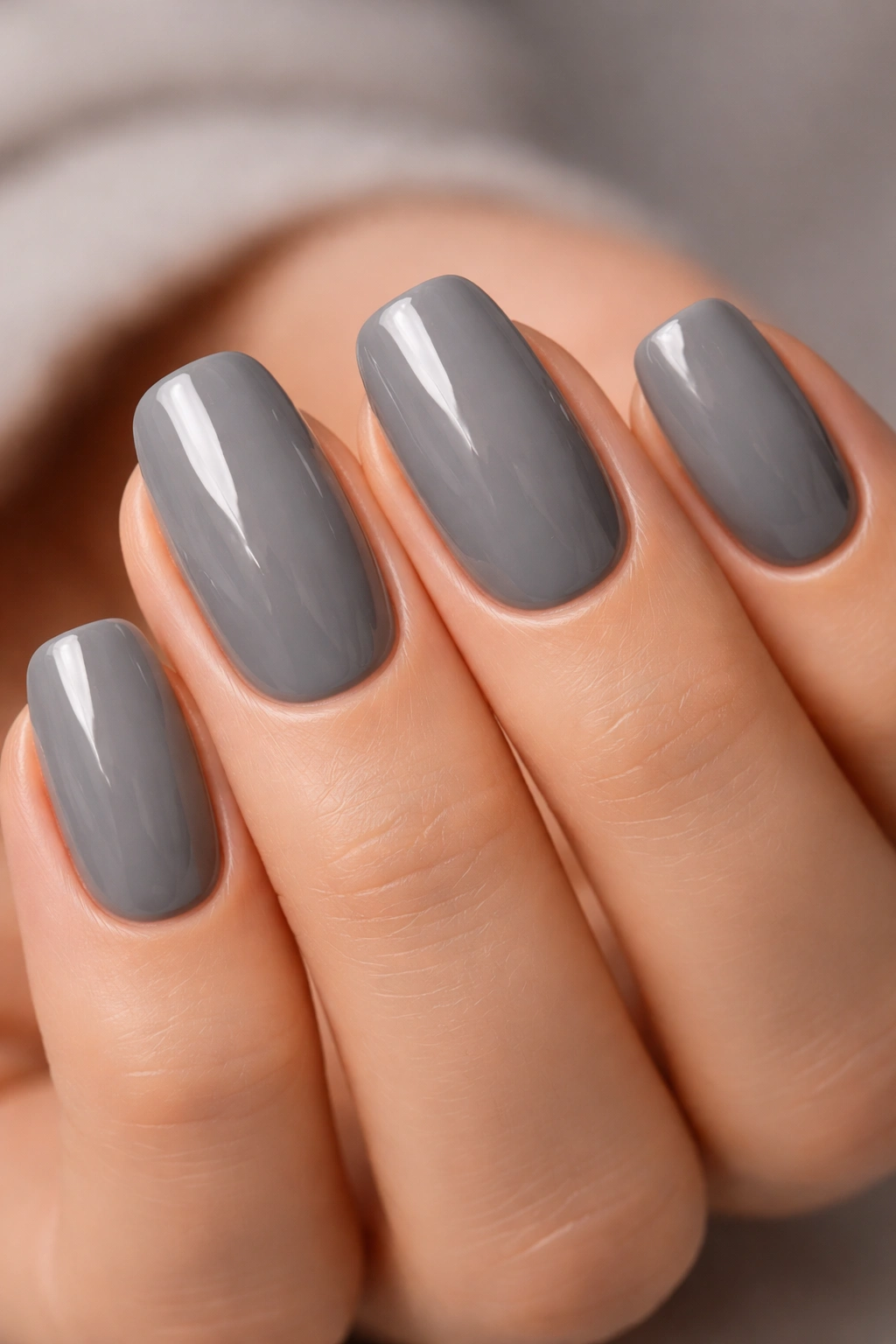 Close-up of nails painted Chinchilly granite gray with glossy finish