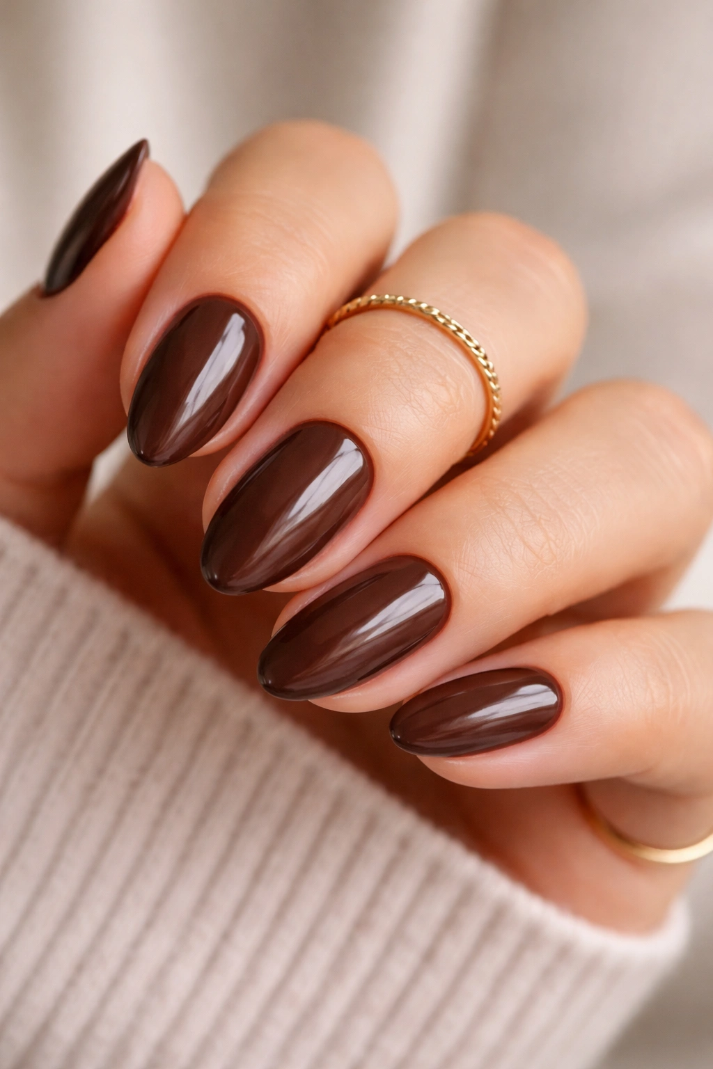 Close-up of chocolate brown dip nails on short almonds with glossy finish