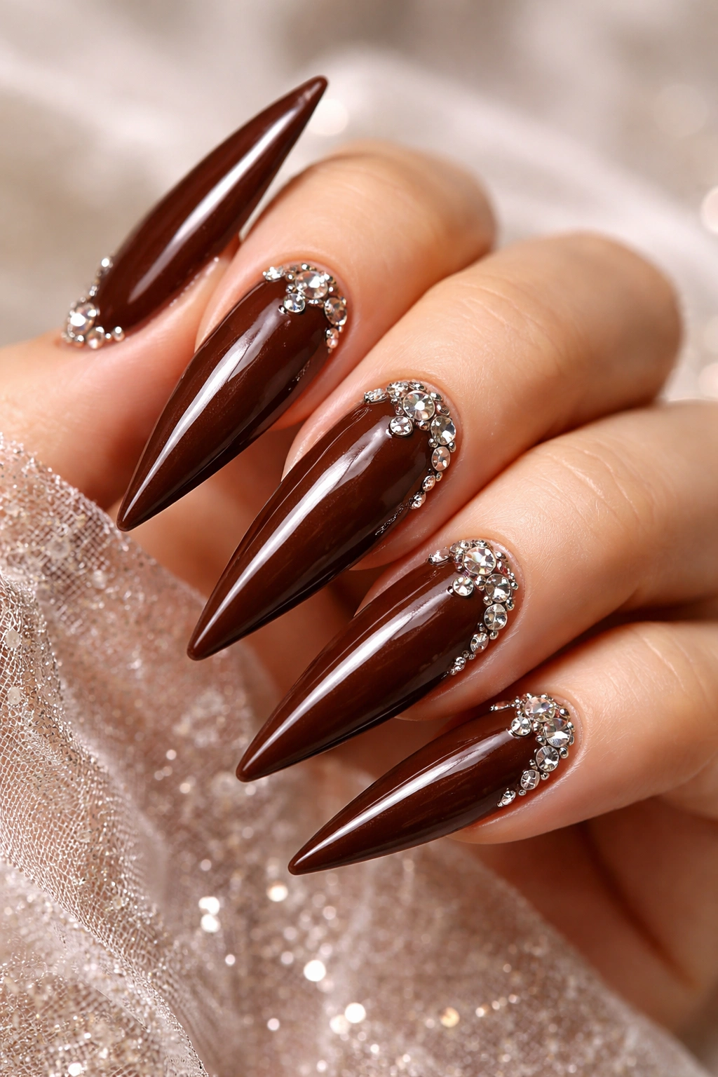 Chocolate brown stiletto nails with rhinestone accents