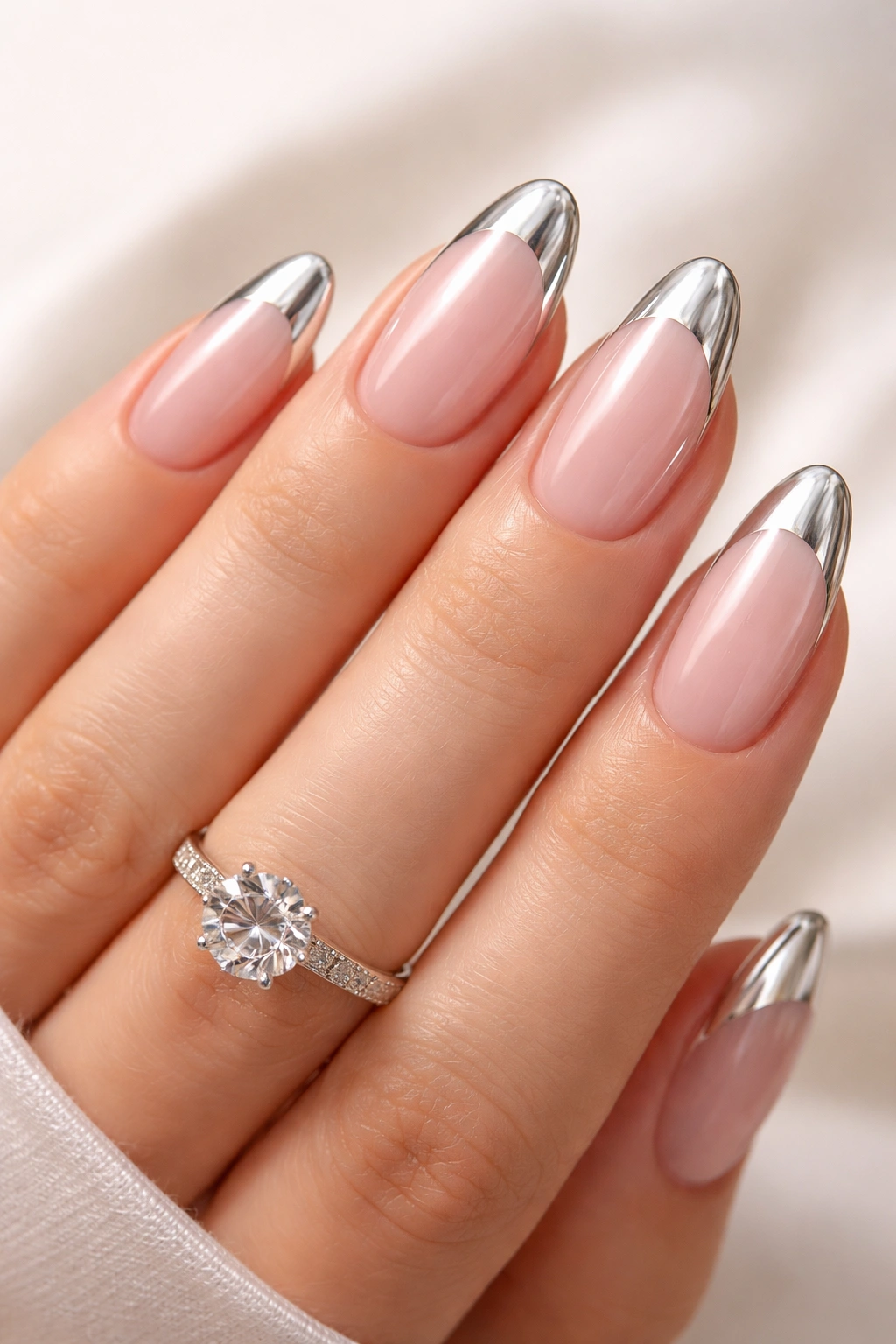 Close-up of nails with chrome french tips on a neutral background