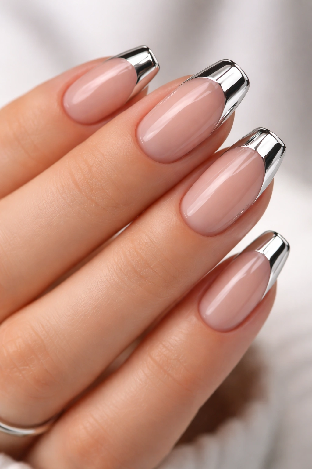Close-up of nude nails with chrome-finished tips