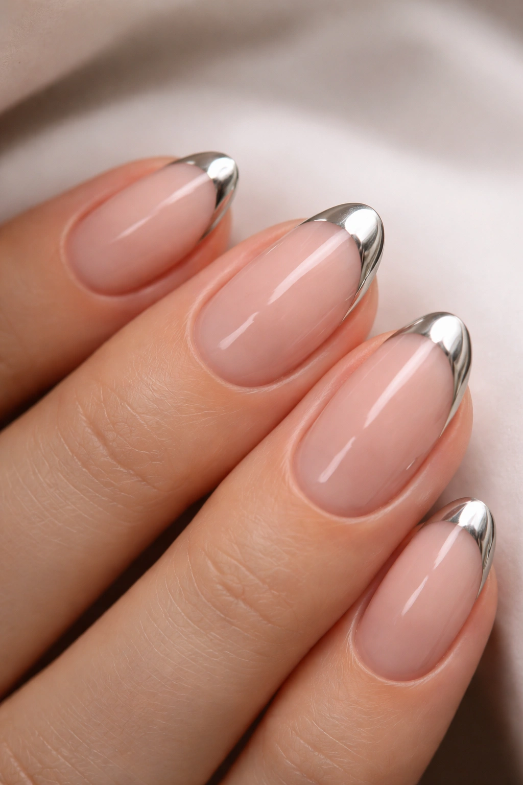 Close-up of a short almond nail with chrome French tip on edge