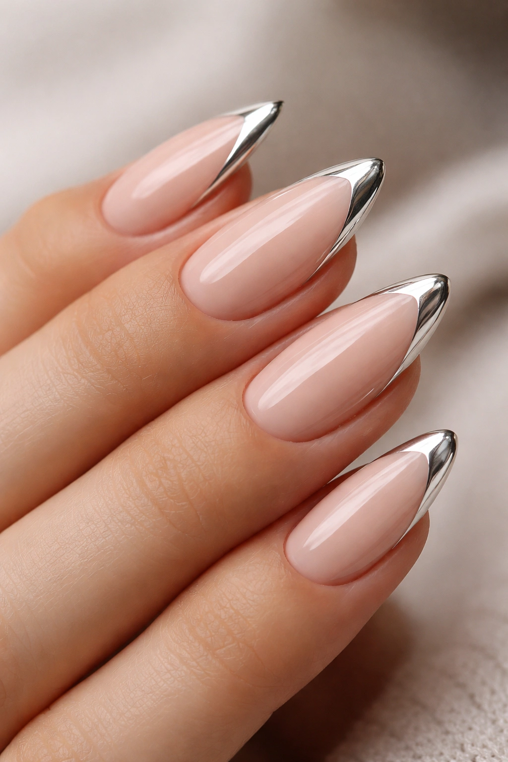 Almond nails with a slim chrome tip on nude base.