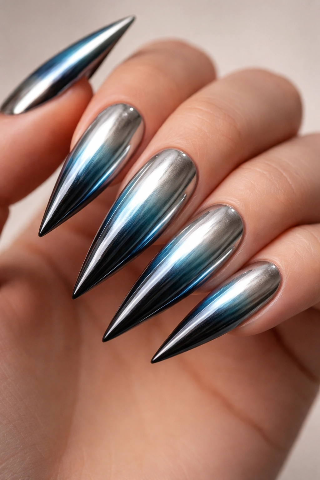 Chrome gradient nails from silver to blue to black on stiletto nails