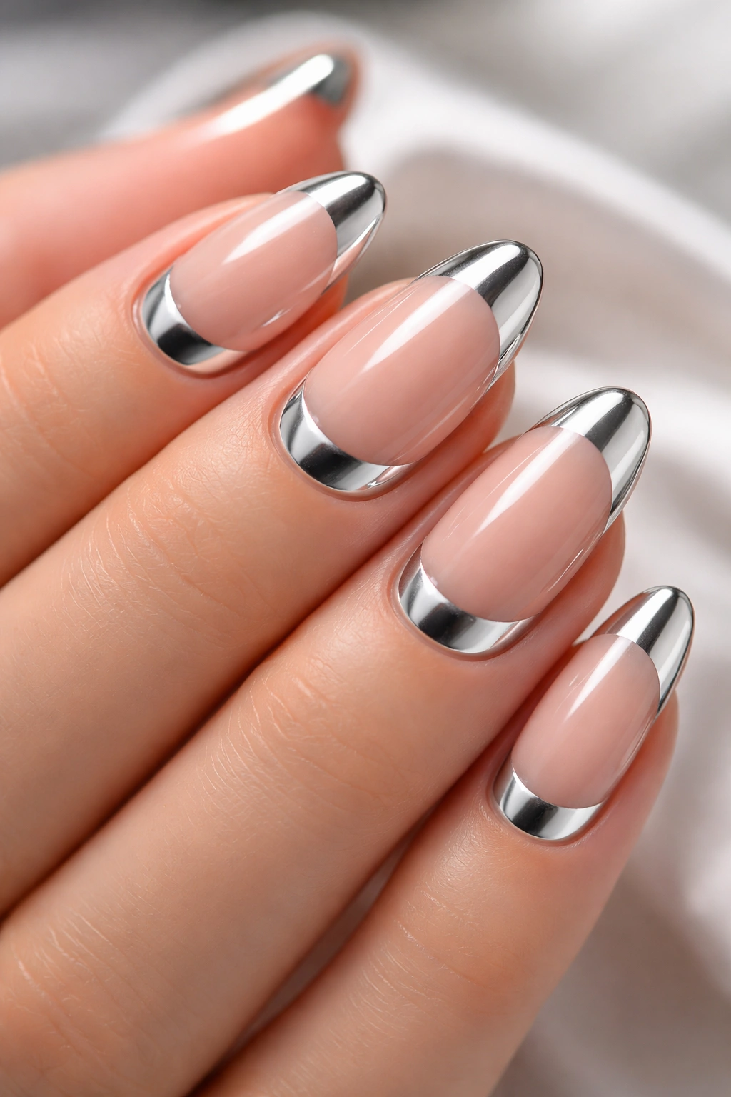 Close-up of nails with curved chrome half-moons at the base on a nude base