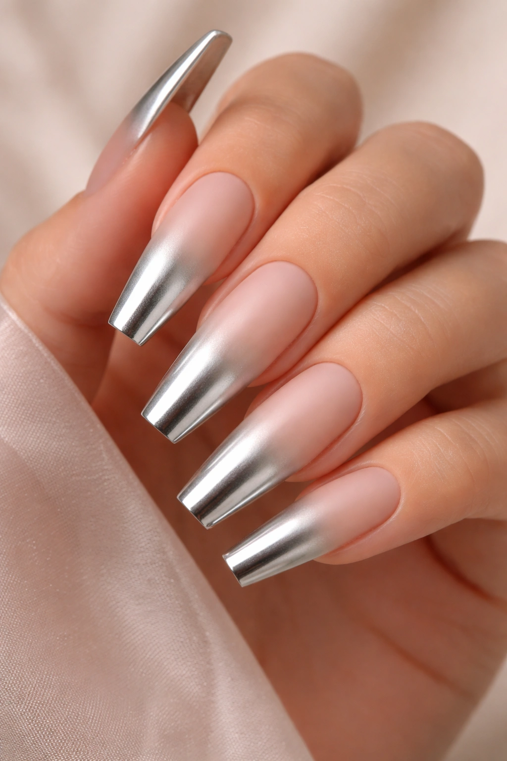 Close-up of curved coffin nails with matte base and chrome tip