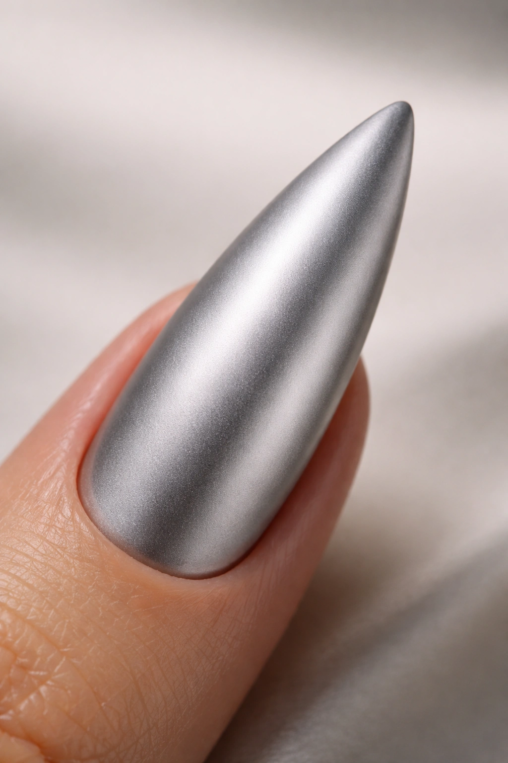 Chrome silver curved stiletto nail with matte topcoat