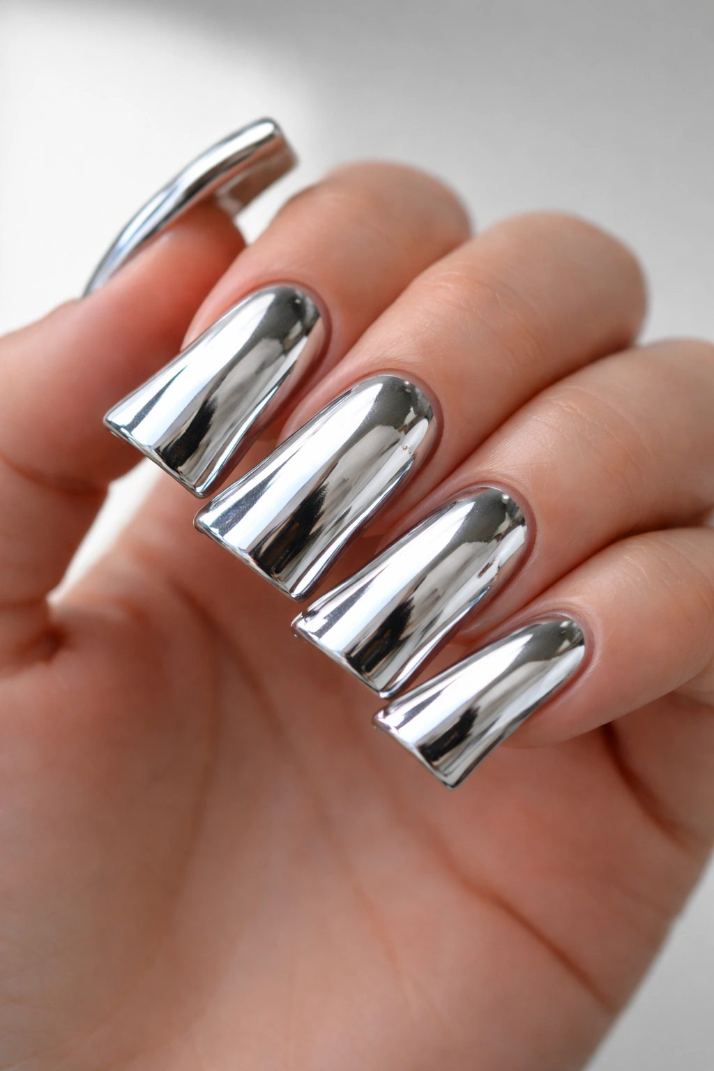 Close-up of chrome mirror duck nails with reflective metallic surface