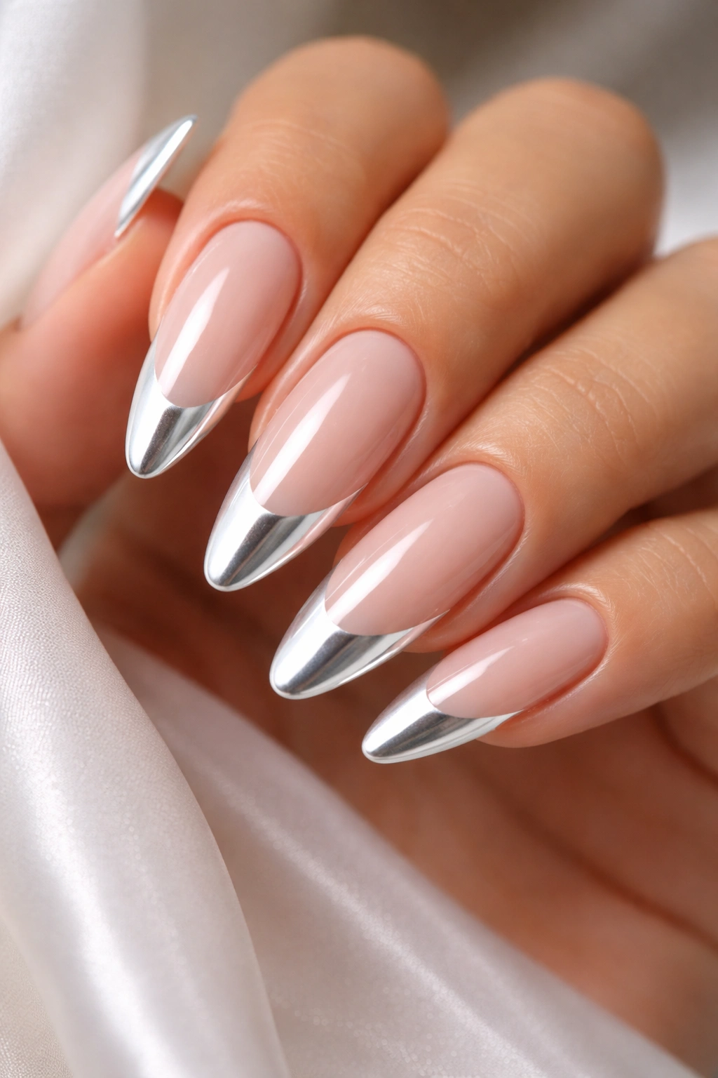 Close-up of chrome white almond nails with pearly tips on a nude base