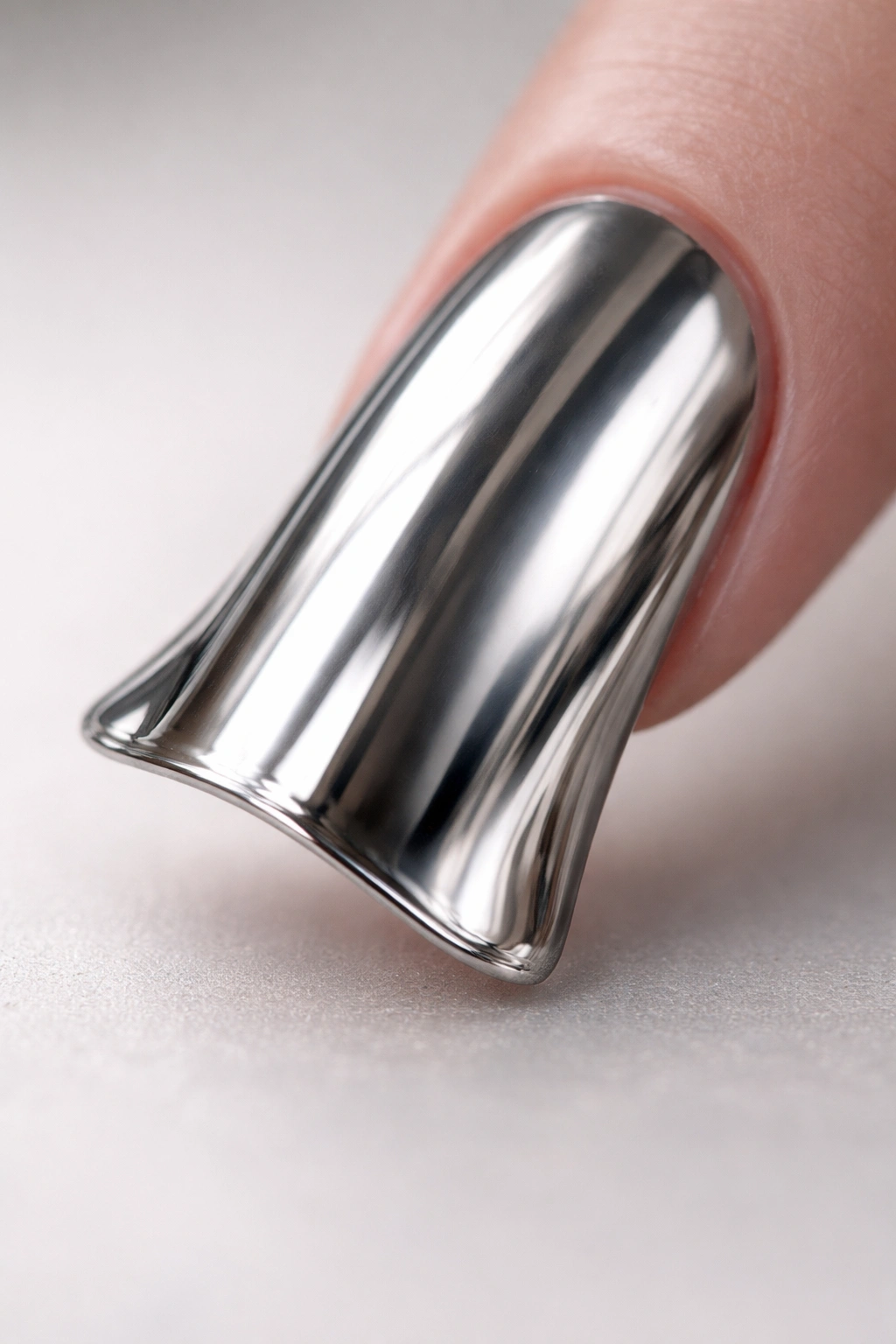Close-up of a duck nail with mirror-like chrome finish on the curved tip.