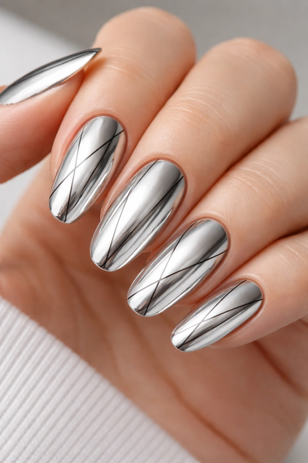 Close-up of chrome platinum long round nails with geometric lines