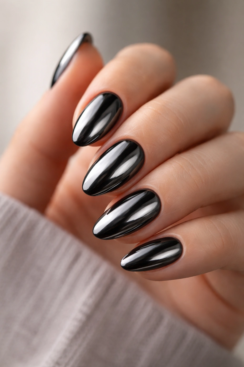 Close-up of short almond chrome nails with a high-gloss finish